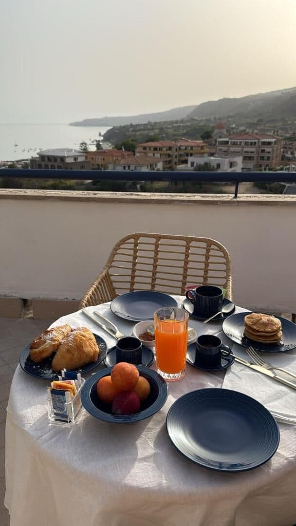 Il tavolo della colazione apparecchiato con la porcellana blu sul roof top