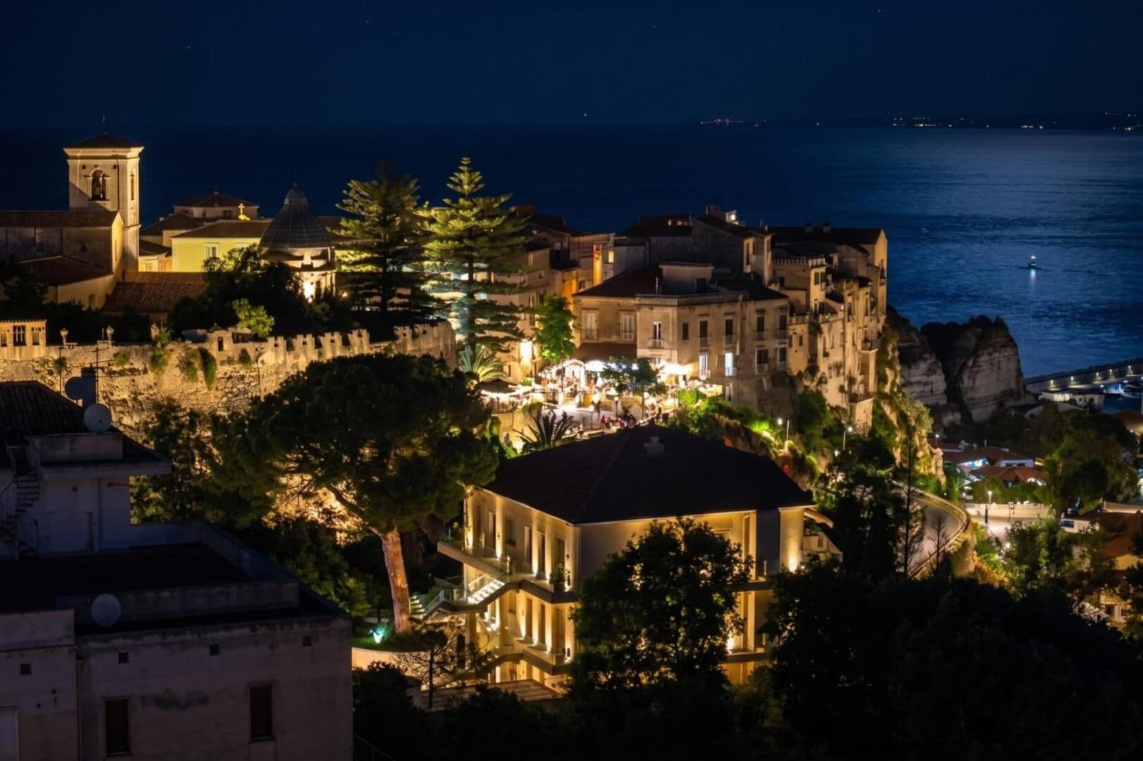 Tropea di notte vista dall'attico: la rupe illuminata e il mare scuro