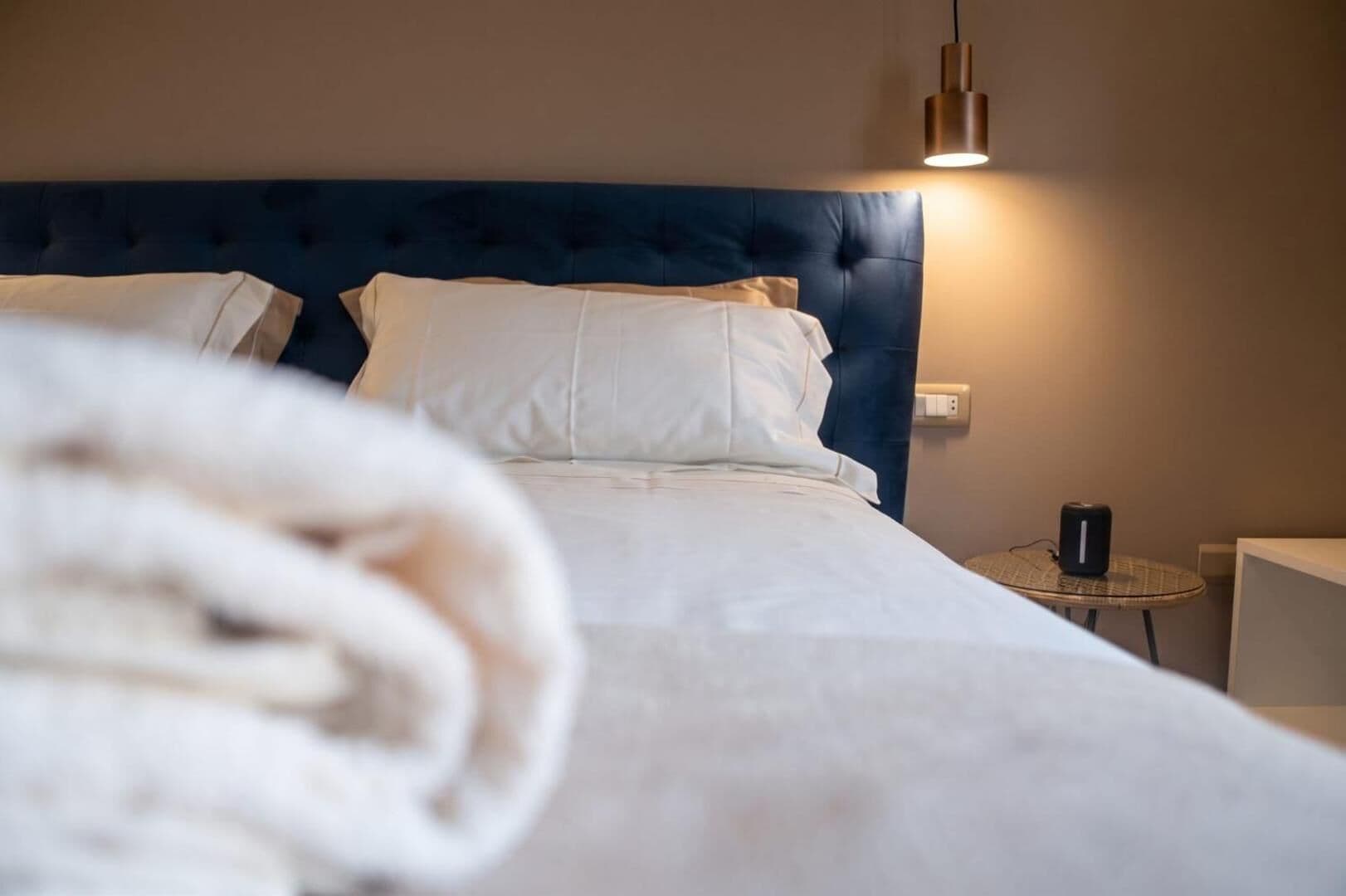 Gli asciugamani piegati sul letto, la testata blu