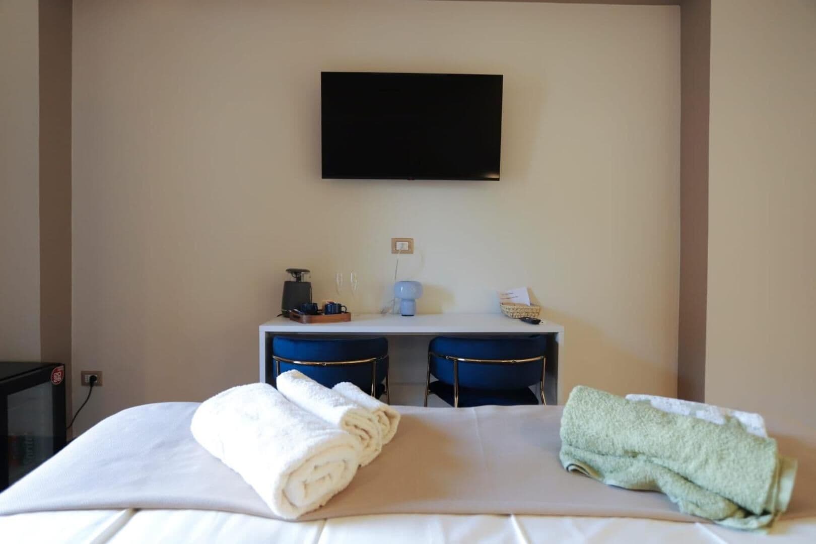 La King Superior con la TV, la scrivania e gli asciugamani sul letto