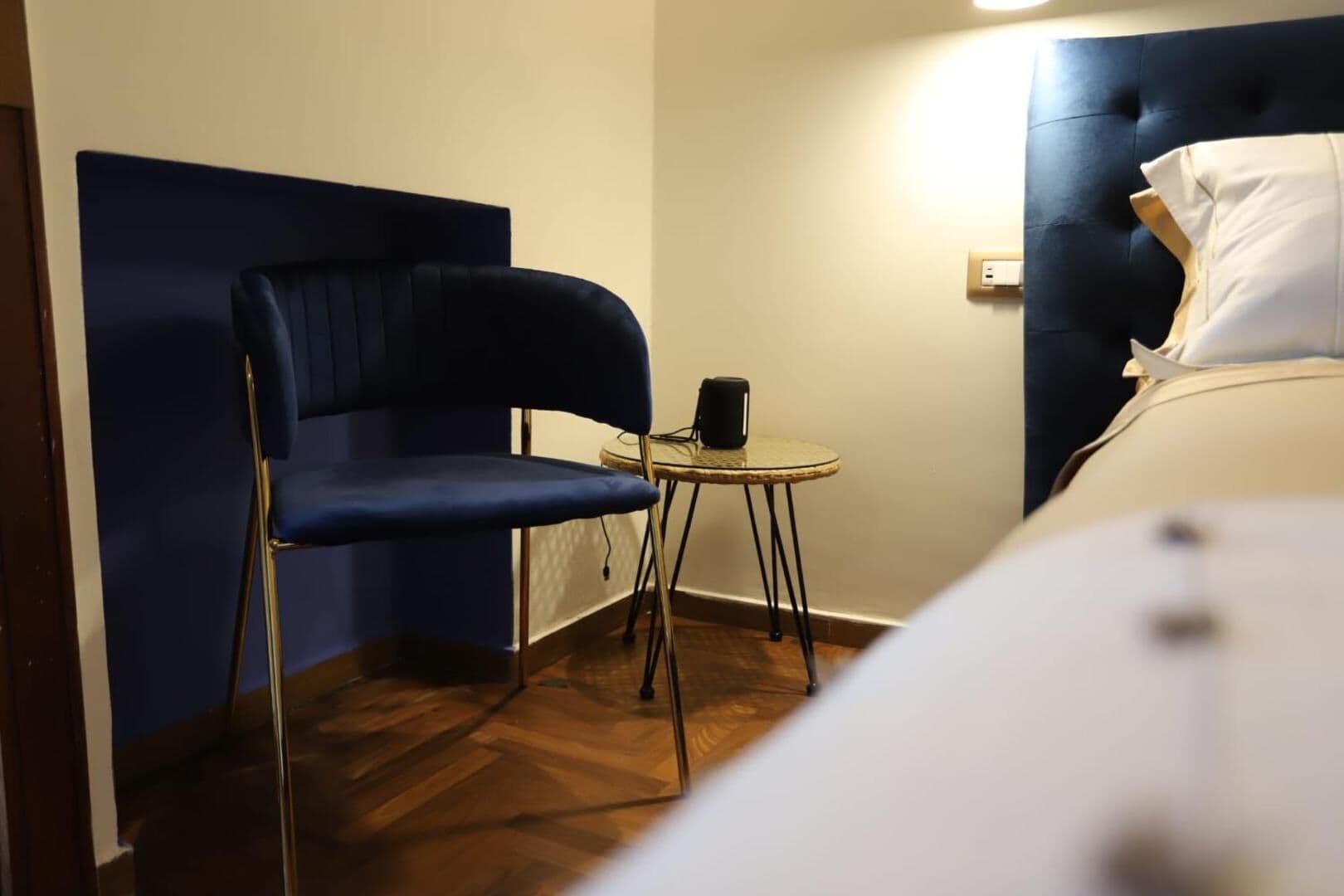 La poltroncina blu e il tavolino accanto al letto