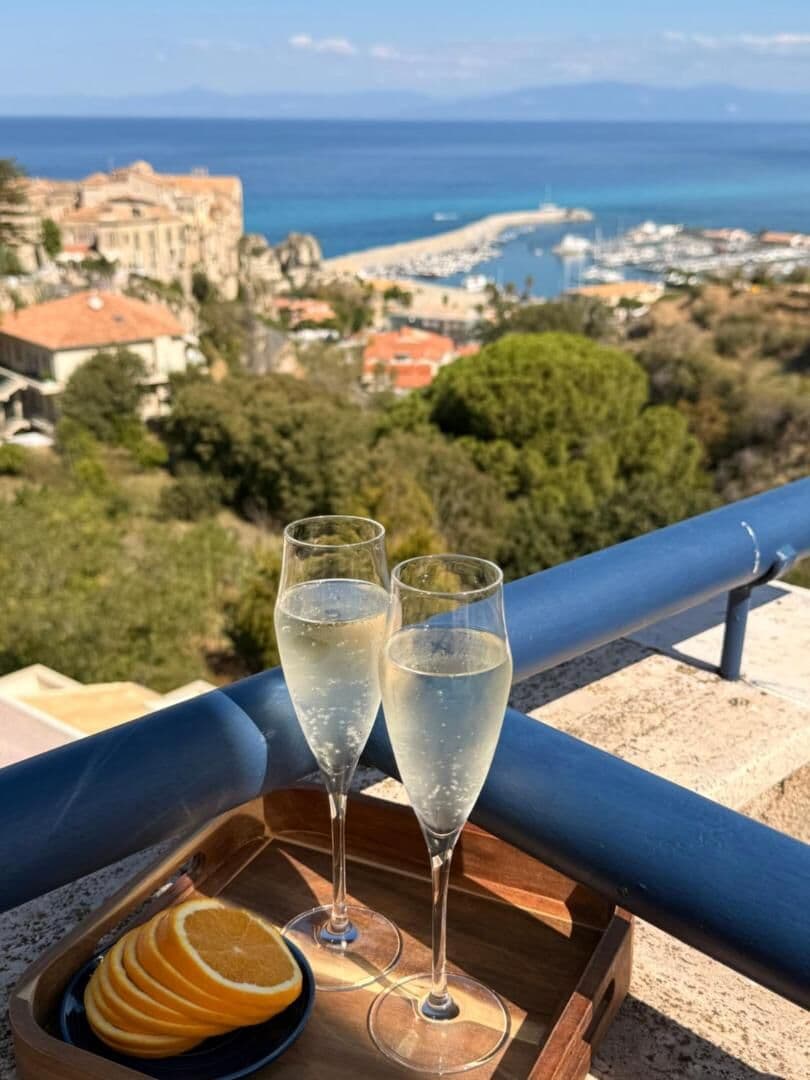 Due calici sul vassoio, davanti alla rocca e al porto di Tropea